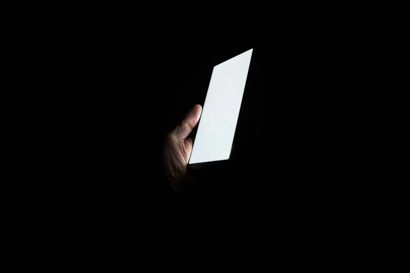A phone held in the dark, its screen the only light